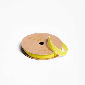 Spool of chartreuse yellow velvet ribbon on a cardboard reel
